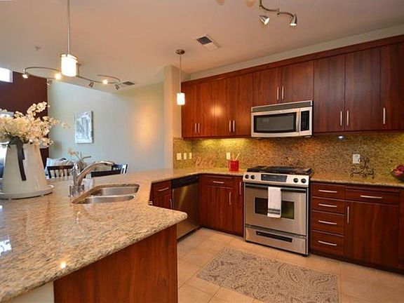 Spacious kitchen featuring stainless steel appliances, slab counters, and modern backsplash
