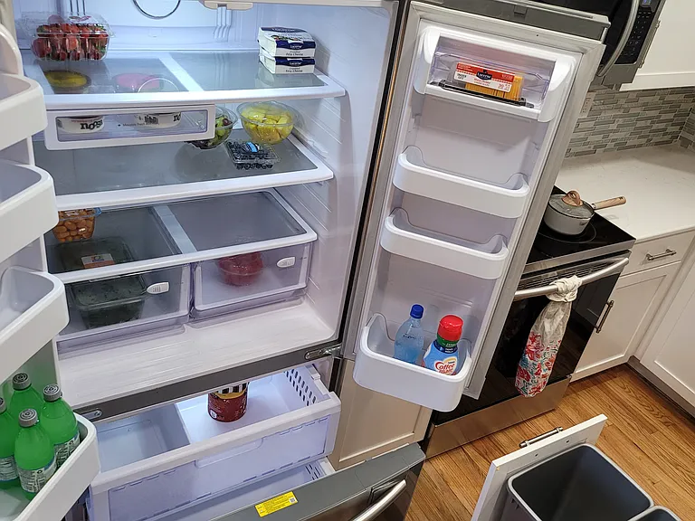 stainless steel fridge and pull-out trash bin built into the center island