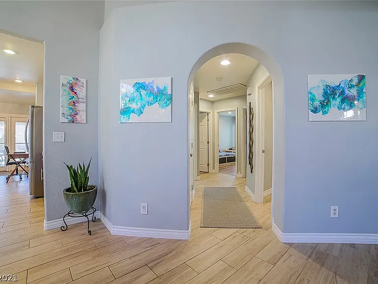 Hallway. Doors from left to right: (1) closet; (2) full bath #2; (3) primary suite; (4) Bedroom #2; (5) Bedroom #3; (6) laundry room / access to garage. Not shown is linen closet also in hallway.