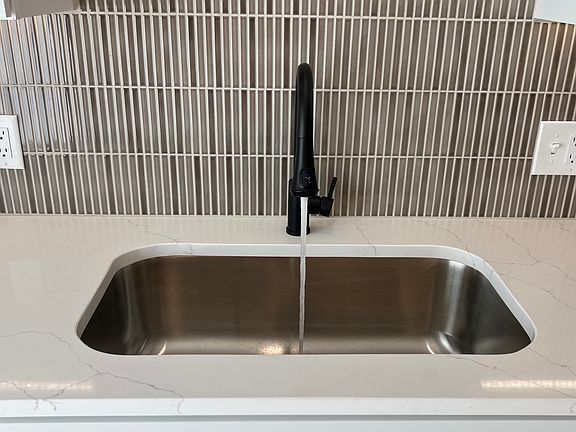 New stainless one bowl large sink. New faucet with water temp sensor. Modern backsplash (2026 tile of the year).