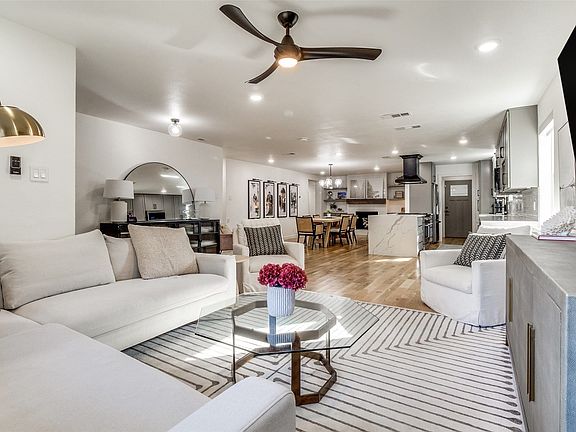 Open concept living area featuring hardwood flooring, recessed lighting, a ceiling fan, and a kitchen with an island and range hood