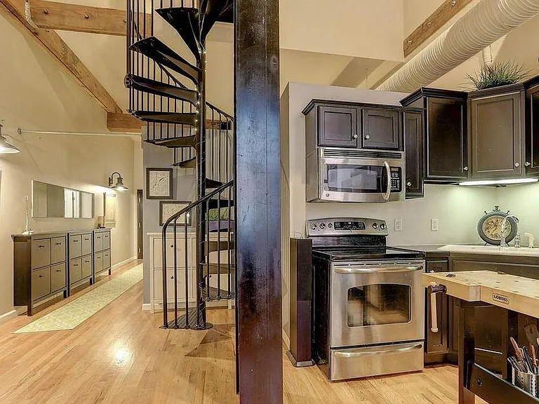 Kitchen with stainless steel appliances & spiral staircase t