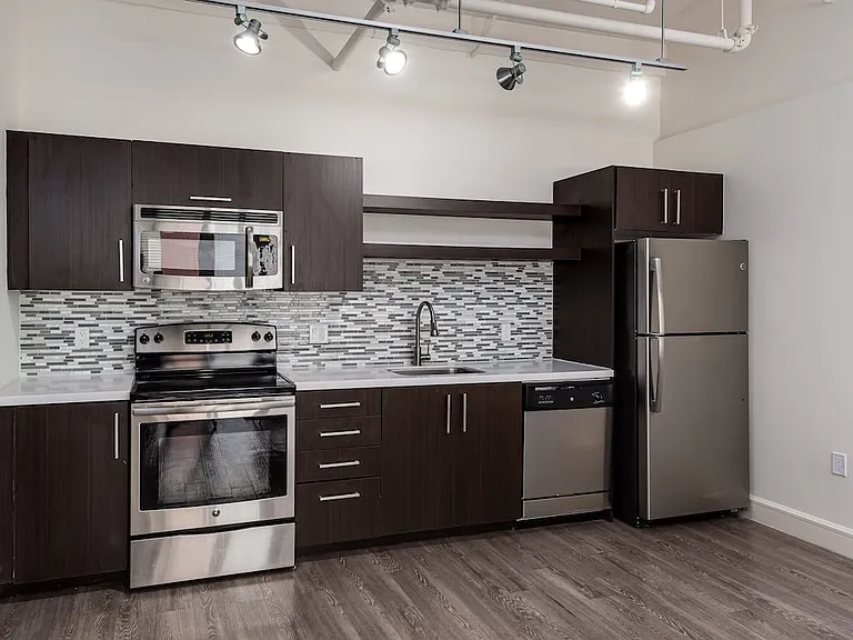Loft Building kitchen with stainless steel appliances and backsplash