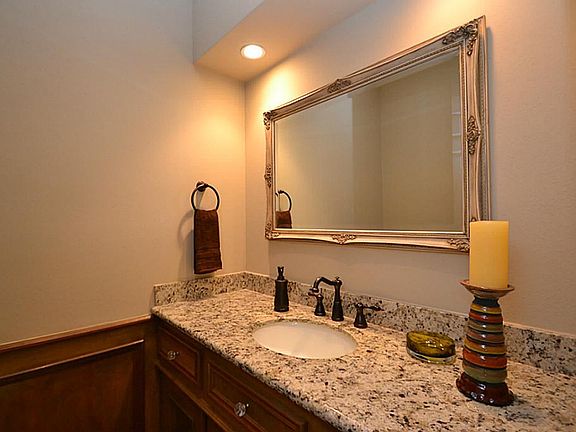 The roomy half bath features granite, updated hardware and woods floors