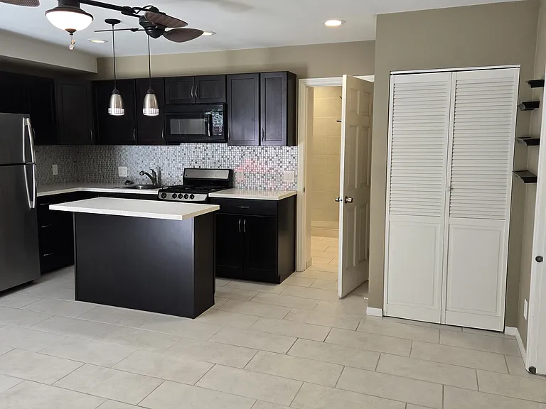 View from the opposite wall showimg the Kitchen and enclosed Washer & Dryer Closet