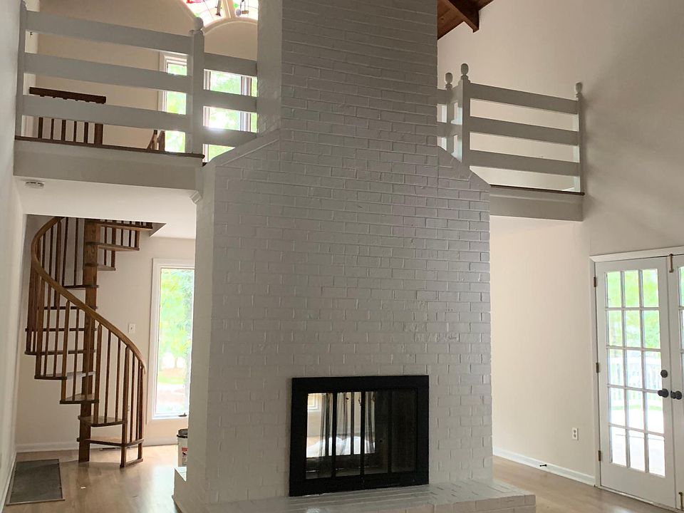 2-story great room with two-sided fireplace, French doors and spiral staircase with loft