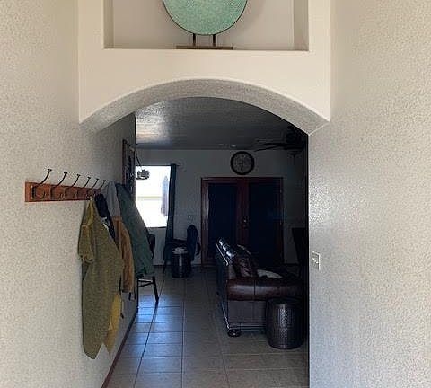 Tile throughout and large coat rack for guests. Back french doors open to covered patio.