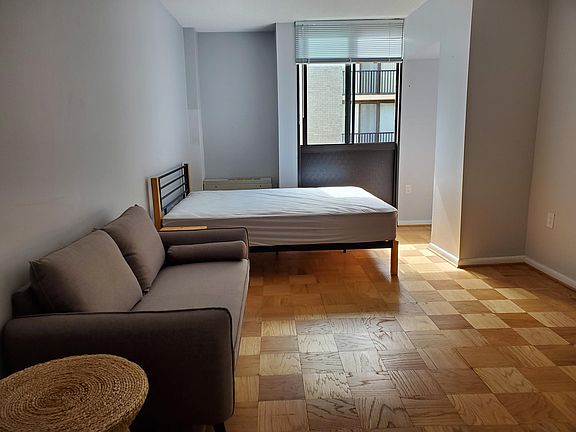 Window in main living area with love seat and queen bed.