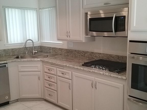 Kitchen with farmhouse Stainless Steel sink, drop down faucet, and dishwasher.