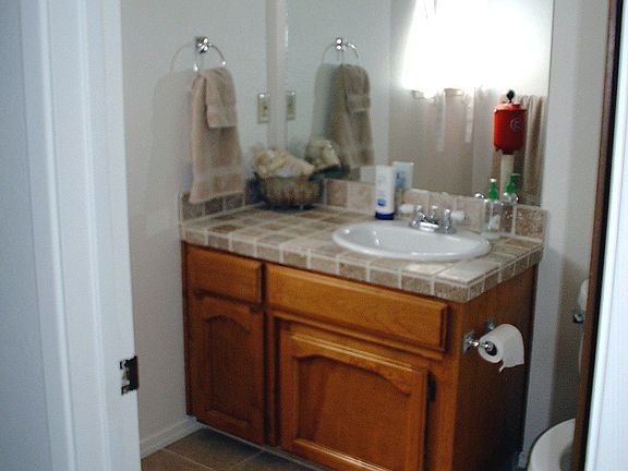 1/2 bathroom downstairs with new tile flooring and counter tops and new paint