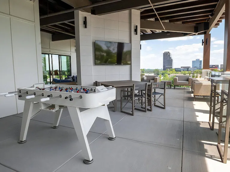 Rooftop Gathering Space with TV, Game Table, and Dining Setup