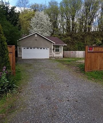 Front view of the home and driveway from the street, The back yard is accessible through a 2nd large gate to the right, where you could possibly store a boat or other toys.  Front yard to the right could also provide storage for a trailer or build a storage shed.