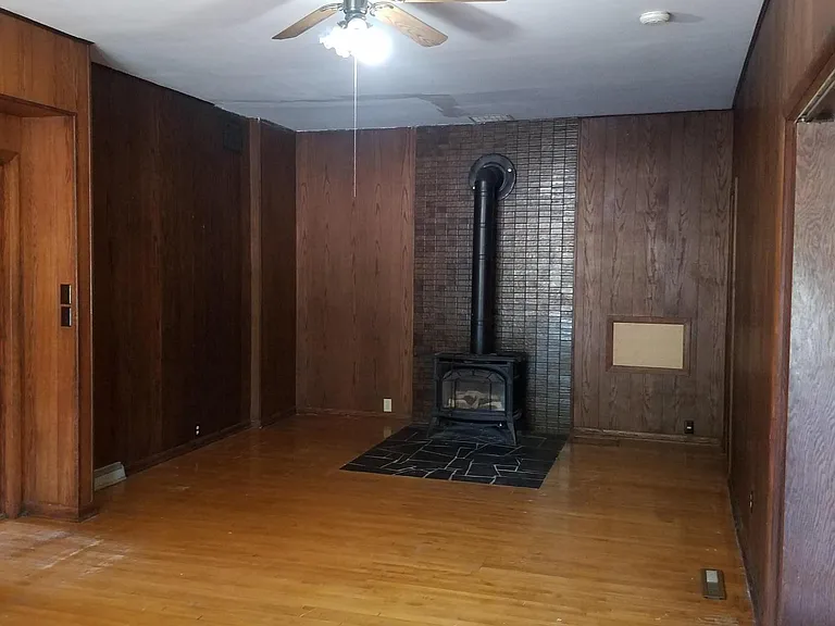 This is the other end of the library room with wood paneling and a gas fireplace stove (for reading!)