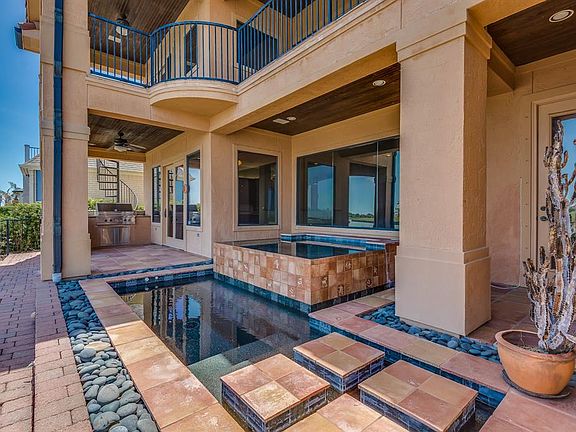 GREAT OUTDOOR ENTERTAINMENT AREAS INCLUDE SWIM SPA, OUTDOOR KITCHEN, A PUTTING GREEN AND LAKEVIEW BALCONIES!
