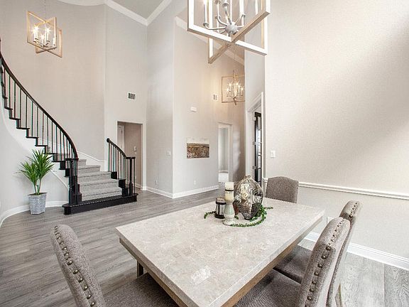 Formal dining space opens to elegant curved staircase