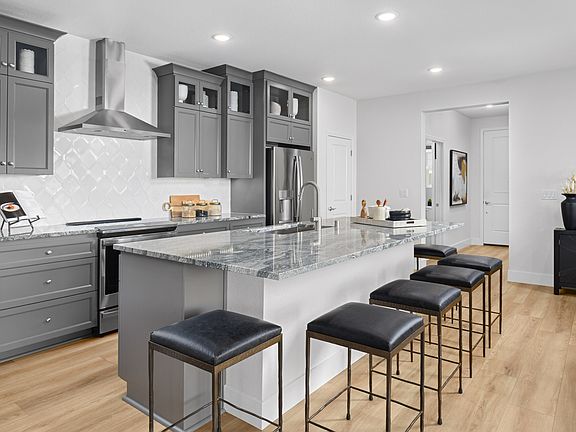 Kitchen with glass upper cabinets and stainless steel hood