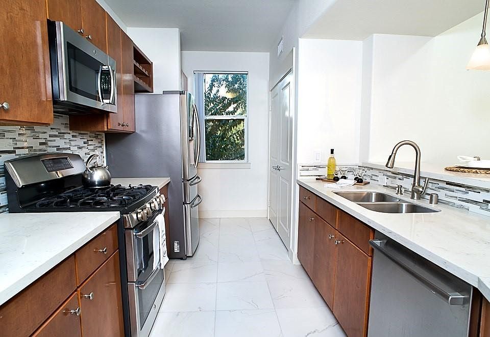 Spacious kitchen with quartz countertop, backsplash and breakfast bar