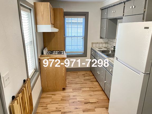 Kitchen with pop up table, gas oven, and refrigerator
