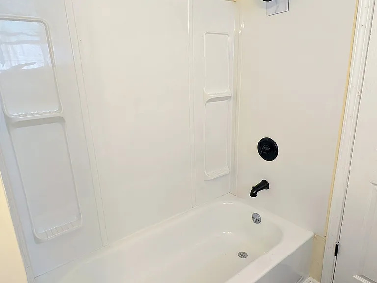 Brand new tub and shower combo with built-in shelving_clean, bright, and ready for daily use.