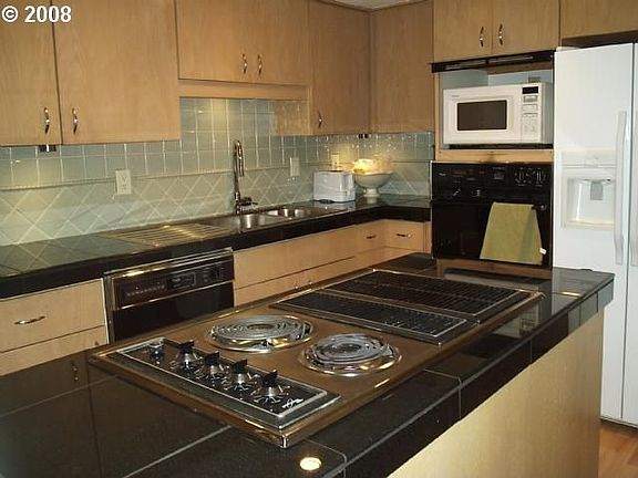 The kitchen has granite counters, tile backsplash, and under-cabinet lighting.