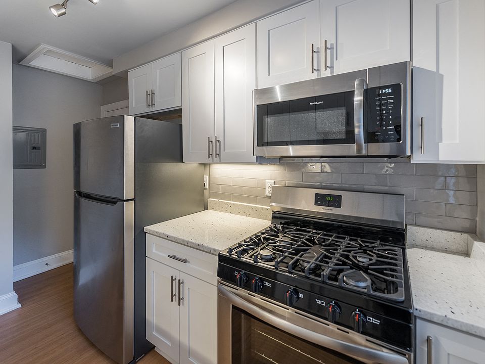 The Cary renovated kitchen with white cabinets, stainless steel appliances and a microwave