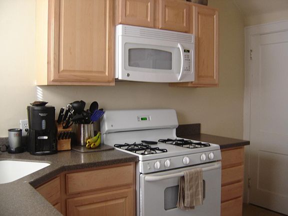 Kitchen with maple cabinets and solid surface counter tops and gas stove and microwave.