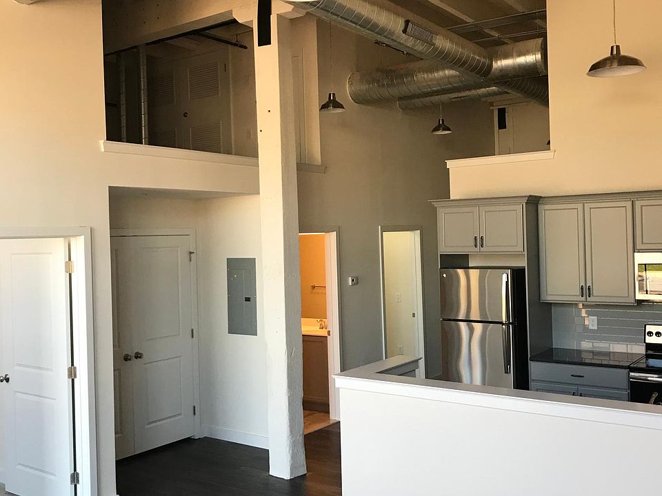 Living space and kitchen with soaring ceiling