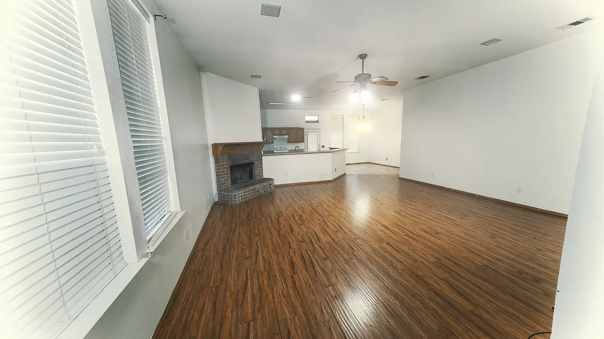 Spacious open-concept living area featuring beautiful wood-style flooring and an abundance of natural light - 218 Canyon Lake Dr