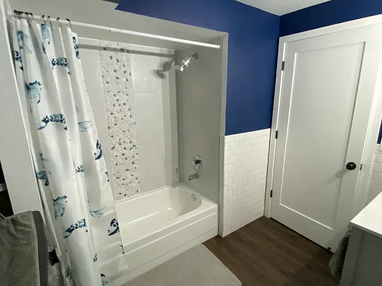 Shower and bath with new tile, shower curtain, and faucets