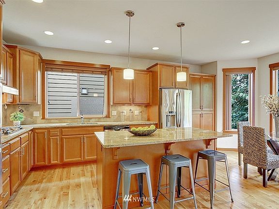 The gourmet kitchen features slab granite counters and full height tile back splash.