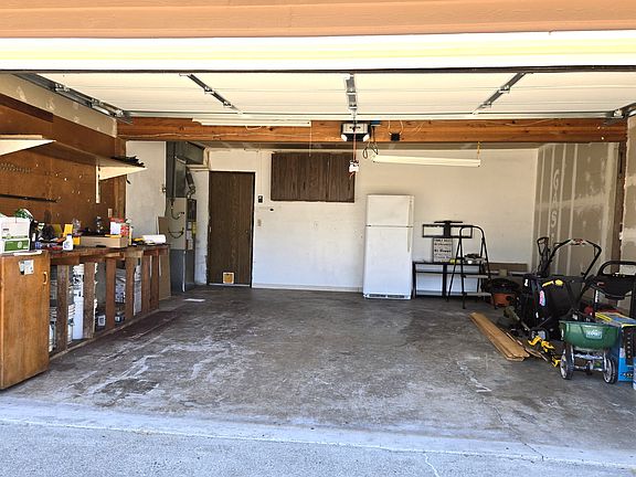 2-car garage with work bench and outside refrigerator.