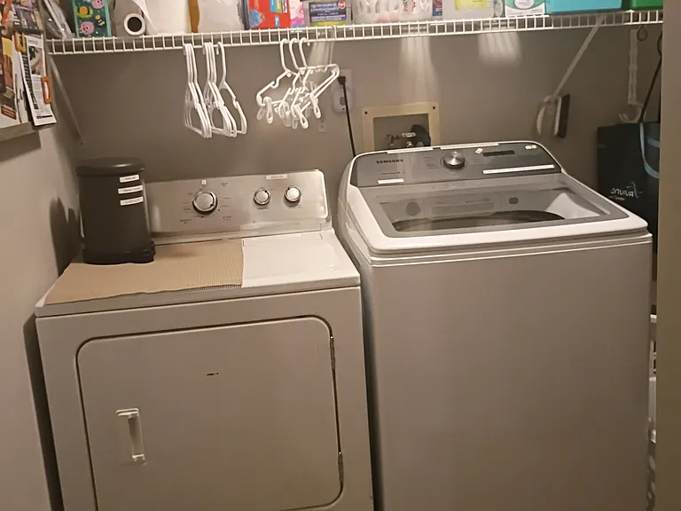 The laundry area is located on the main level next to the pantry, with both spaces combined into one convenient room.