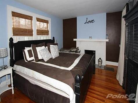 The first floor has a living room that is currently used as a bedroom. It has a half bath adjoining this room. Shutters add to the privac