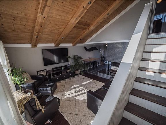 View of living room, fireplace, dining area and stairs to the loft.