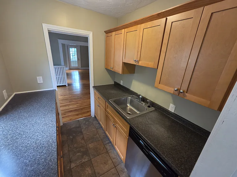 Kitchenette area with additional storage and stainless steel dishwasher.