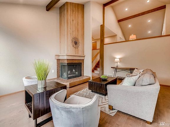 Beautiful main floor living room off the entry way with cozy wood burning fireplace and gorgeous new engineered hardwood flooring