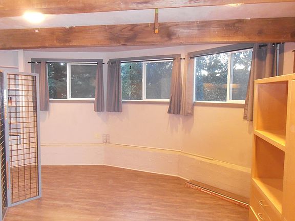 Living Room has 8' long x 5' tall x 2' wide custom media cabinet. 3, 5' x 3' windows with black-out drapes. All new hi-end flooring and exposed beam ceiling. So much lighting you won't need lamps.
