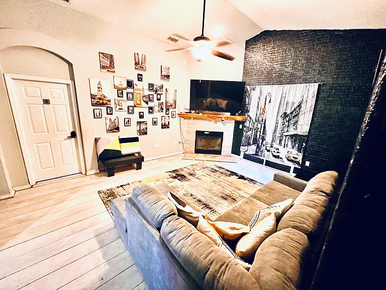 Spacious shared living room with comfortable seating, wall-mounted TV, and a fireplaceideal for relaxing or movie nights.