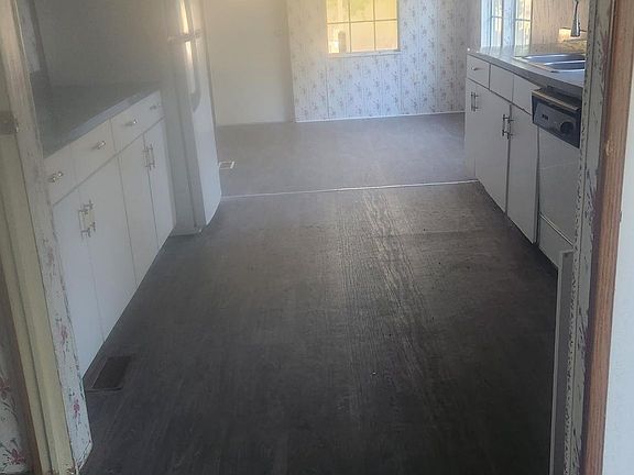 Kitchen area. Eating area at back wall. Laundry to the left. Side entry with covered parking.