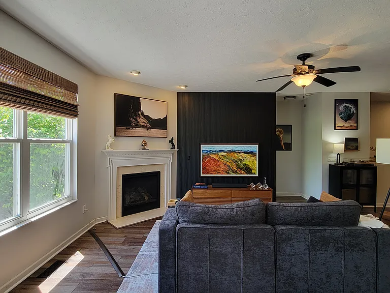 Sleek slat panel accent wall in fireplace/living area. Say goodbye to tangled wires_the home features cord-concealed, flush-mounted TV setups, allowing for a clean, gallery-like look in your primary living spaces.