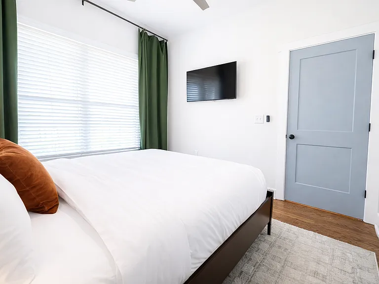 Located on the main floor, the Krog Suite is a relaxing queen room with hotel-level comfort. Enjoy plush linens, Smart TV, ceiling fan, bedside tables with charging ports, dresser, blackout curtains, and stylish designer decor.