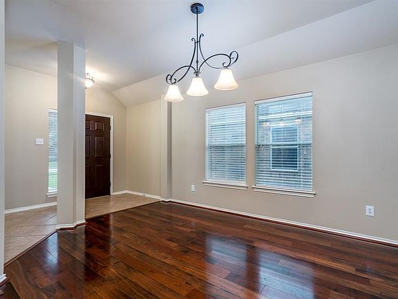 A pretty chandelier highlights the formal dining space! Two large picture windows create additional lighting ambiance!