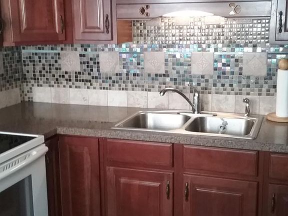Kitchen with cherry cabinets, stainless double sink, beautif