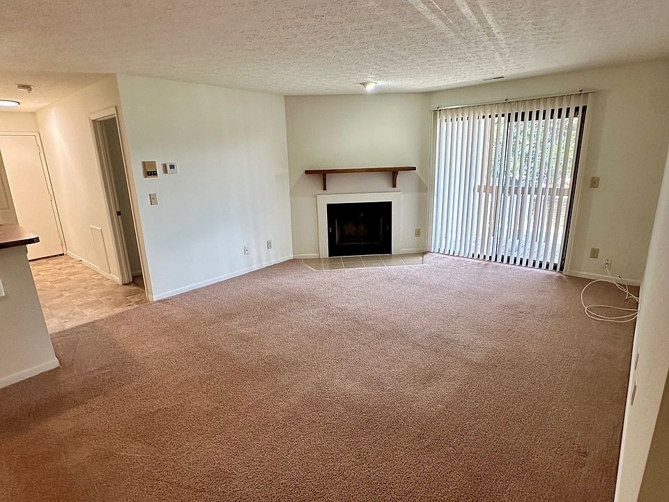 Living room in 2176 E- sliding glass doors to balcony, wood burning stove and hallway to entry on far left