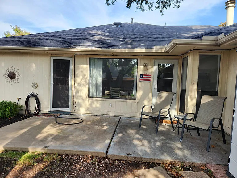 Quiet back patio with lawn furniture, mature trees, privacy fence for pets and peace.