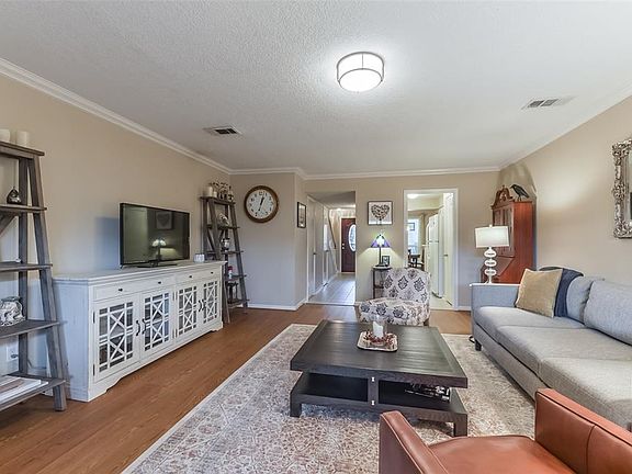 Another view of Family Room from the back highlights the beautiful new vinyl wood floors, crown molding and neutral color scheme ready for move in!