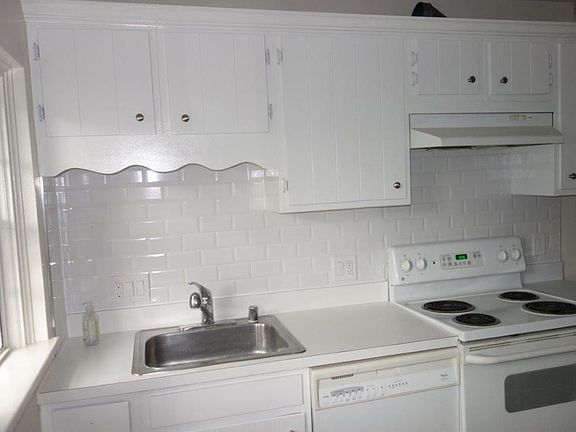 Kitchen with NEW stone countertops, NEW over-the-stove microwave/fan and NEW refrigerator.