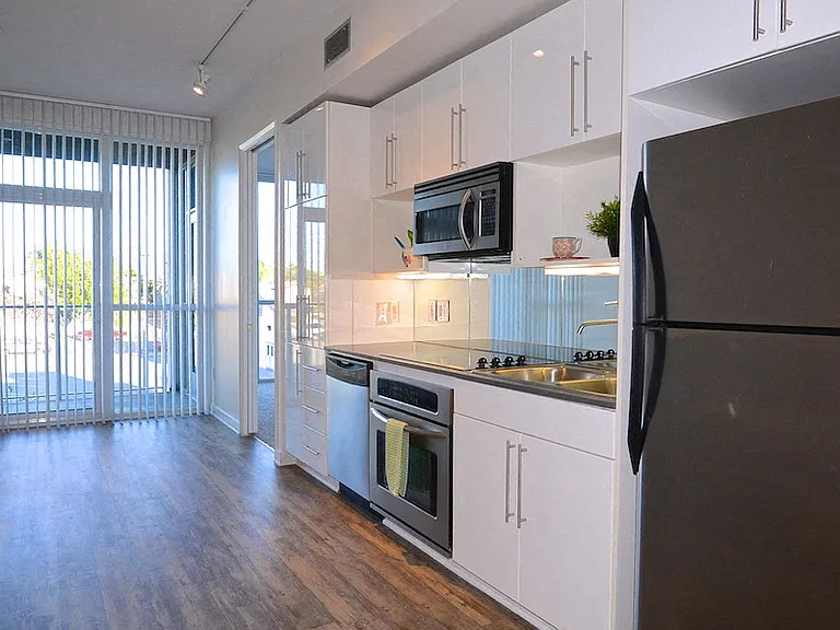 Kitchen with hardwood floors, stainless steel apliances and patio access at 12th Street Lofts in National City, California.