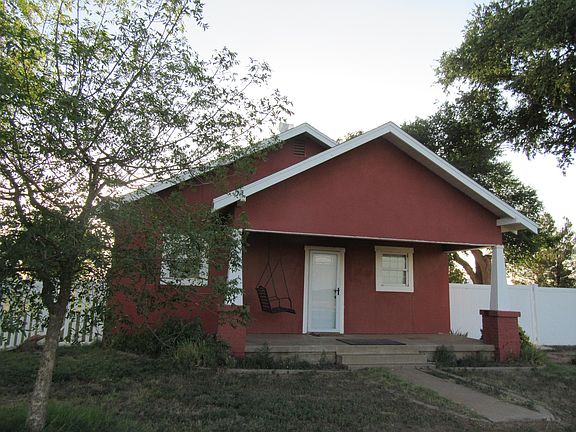 Front porch with flowerbeds and swing.