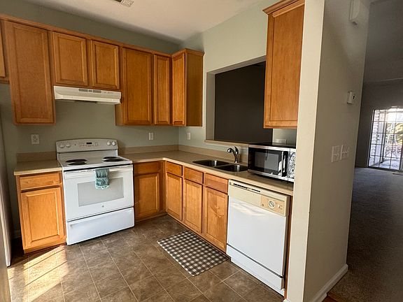 Kitchen with stove, refrigerator, panty, microwave, dish washer and garbage disposal